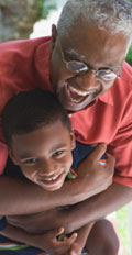 [photo: man hugging child]