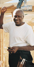 [photo: builder working on house]