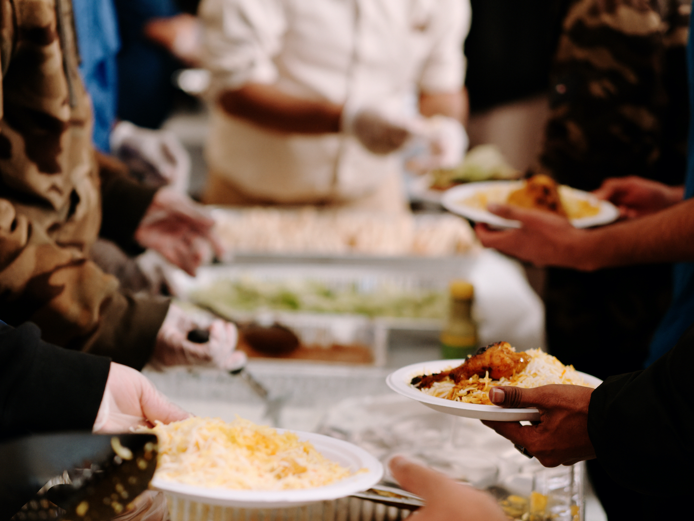 Hands serve food from trays