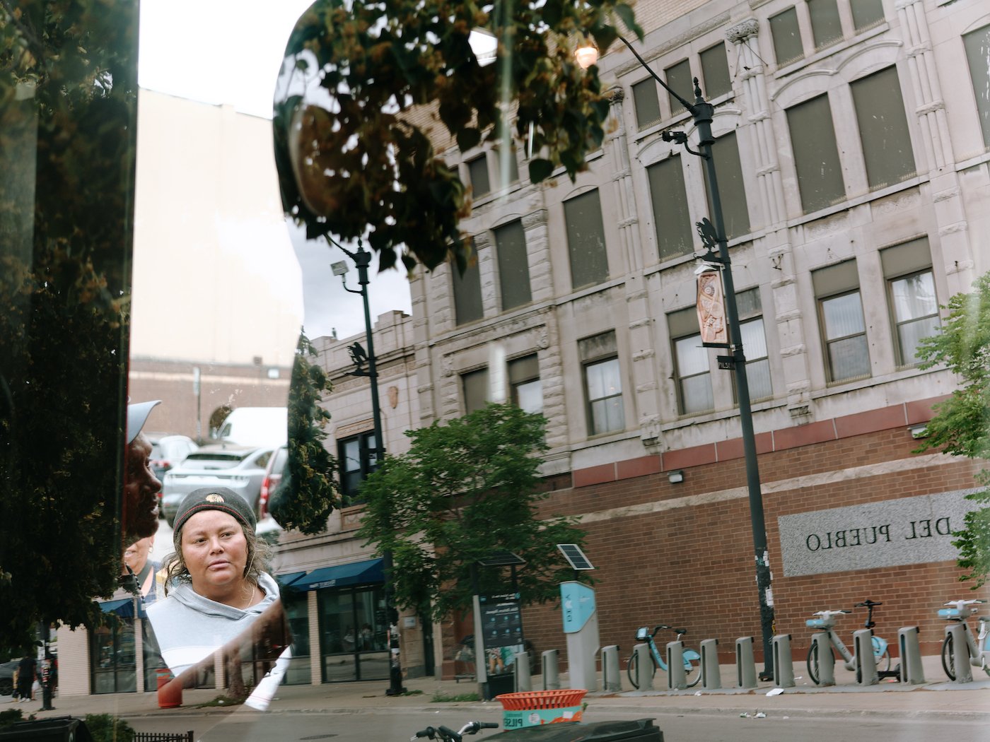 The reflection of a woman in glass next to a building