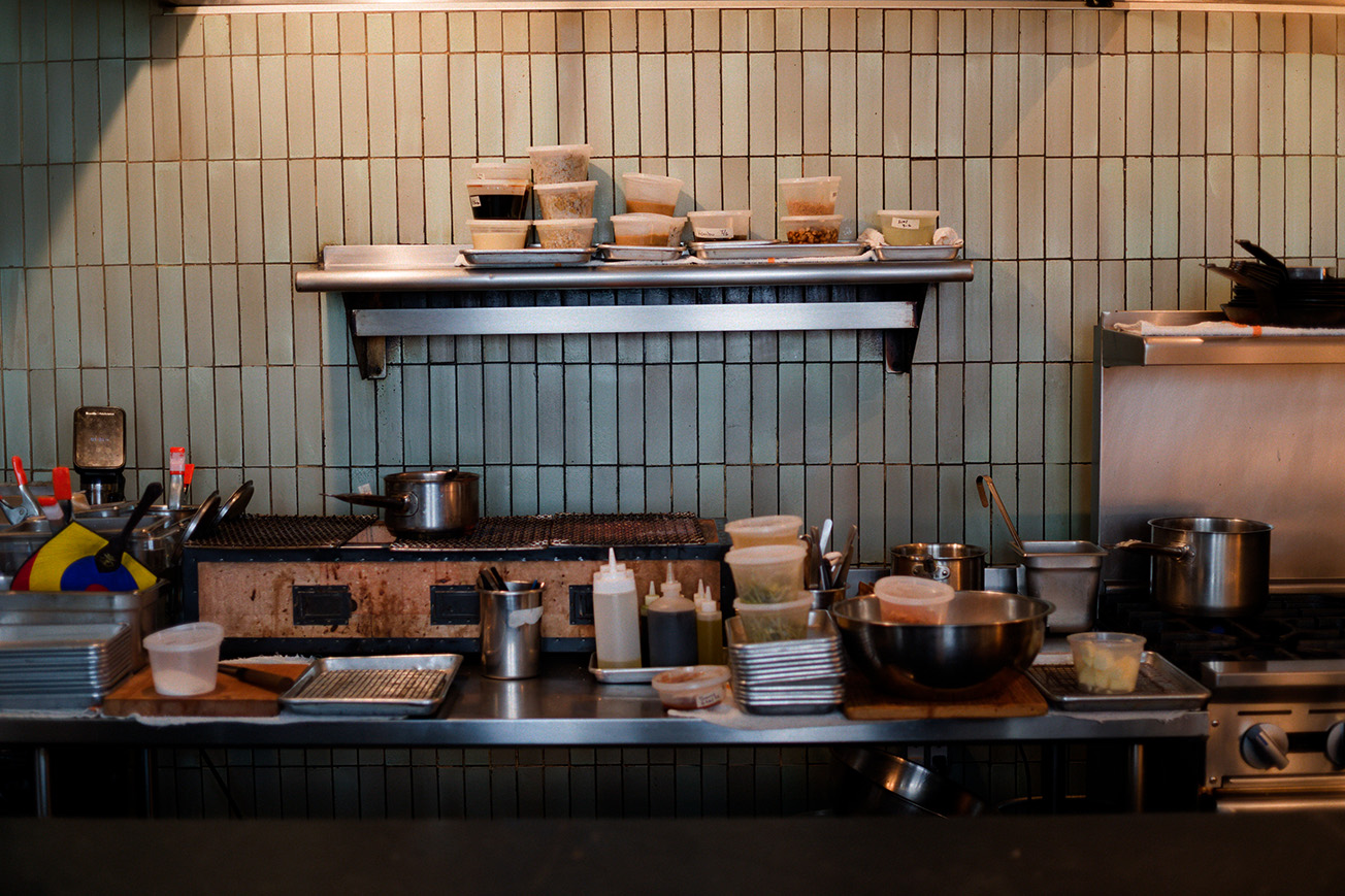 A restaurant kitchen with many deli containers