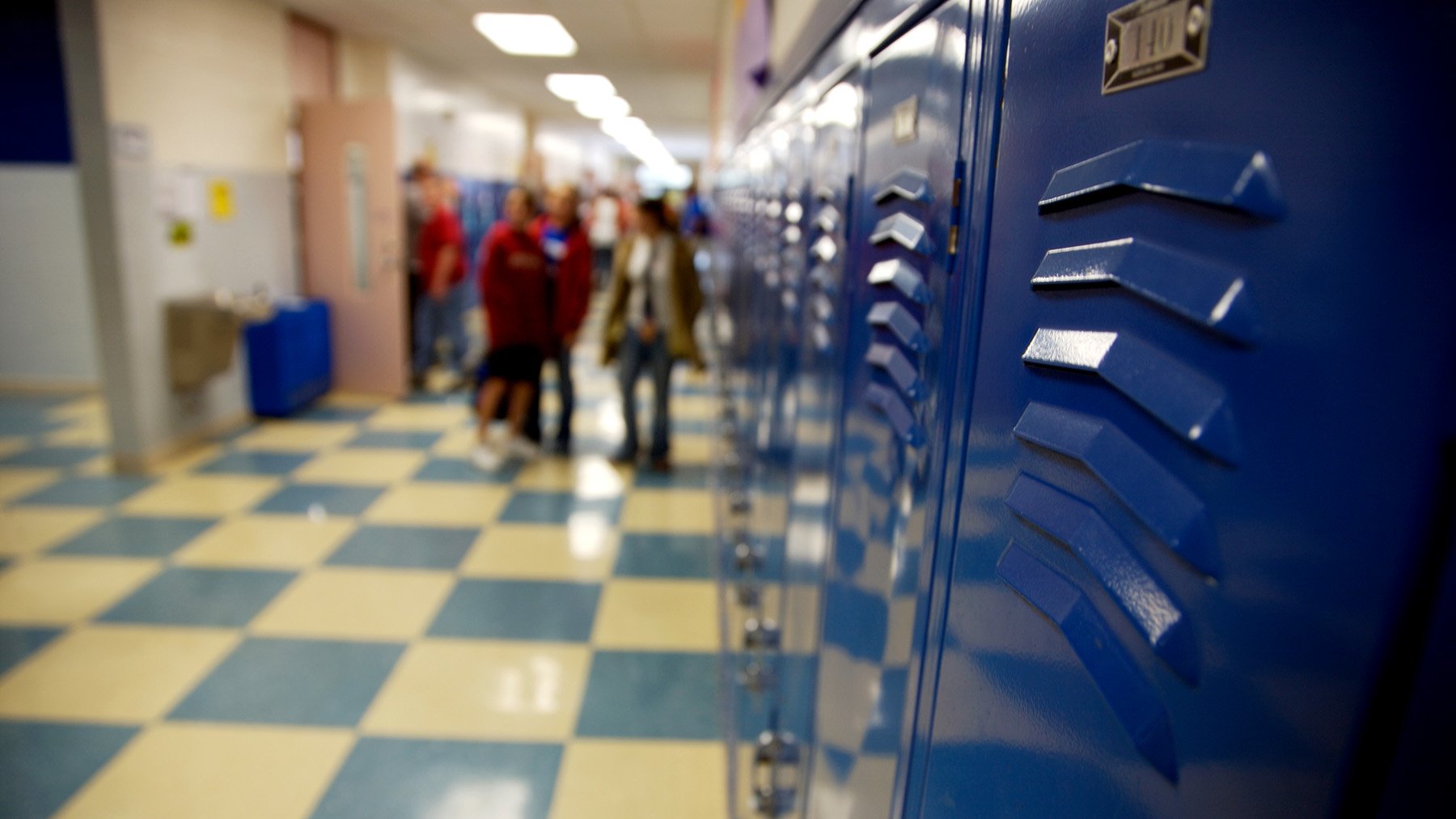 Looking down a school hallway with lockers and students in the distance