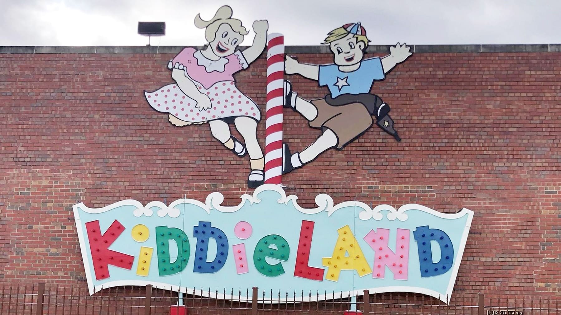 Kiddieland sign in front of a brick wall