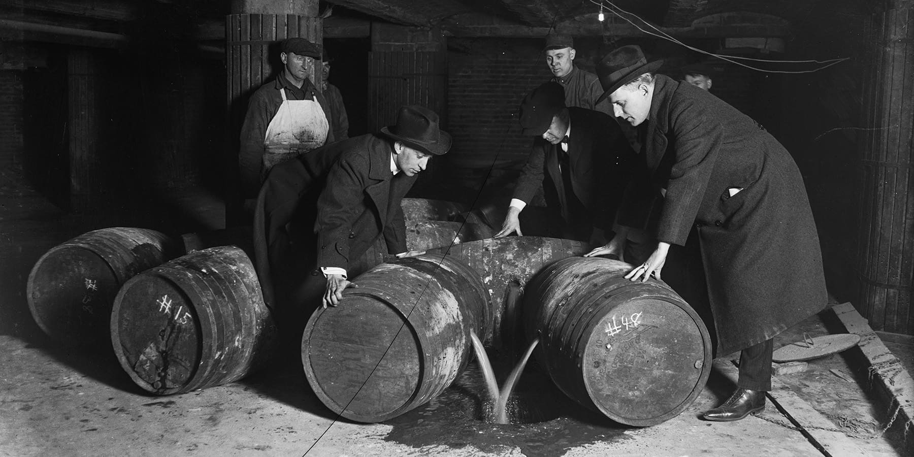 A group of officials pours booze out of barrels in 1921.