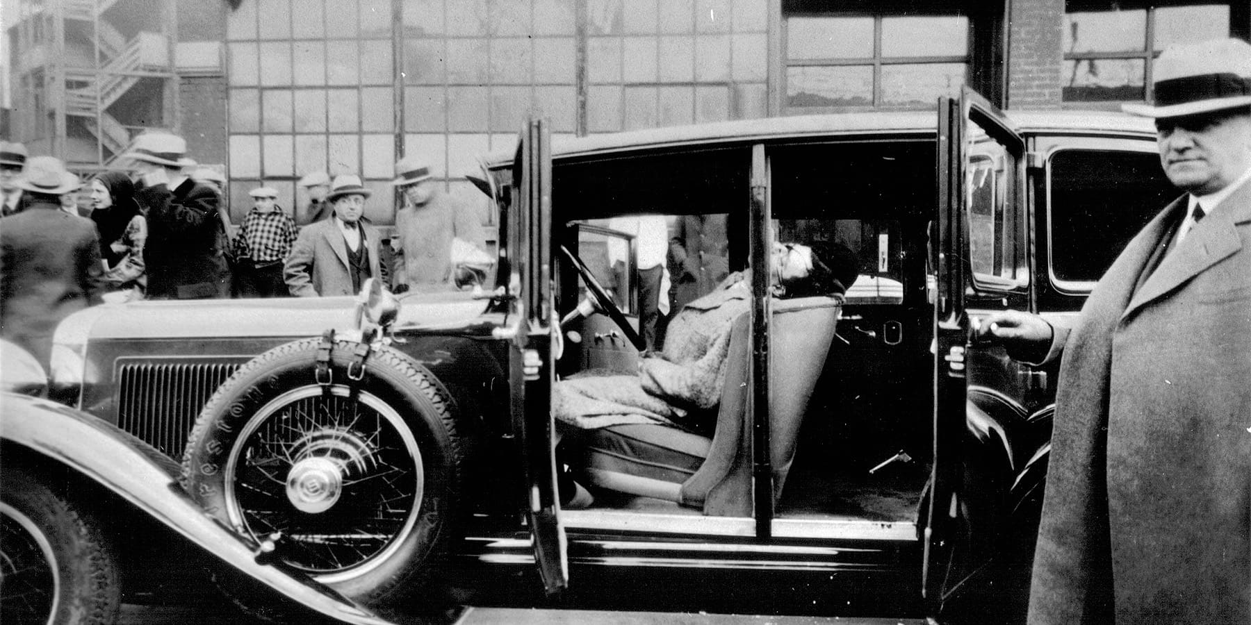 A victim of a shooting lying dead in a car.