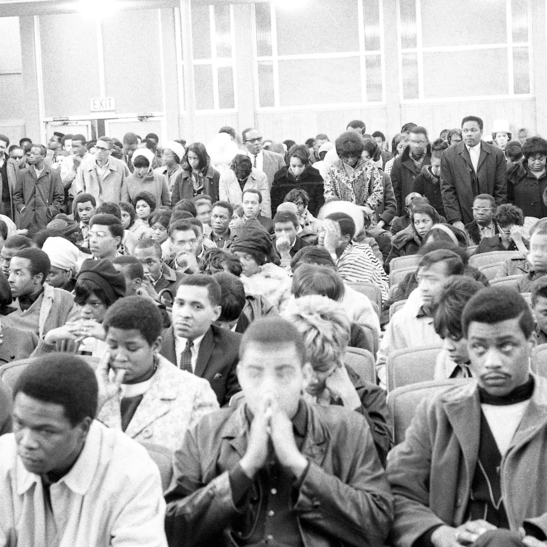 A black and white photo shows a large group of people seated closely together at Liberty Baptist Church.
