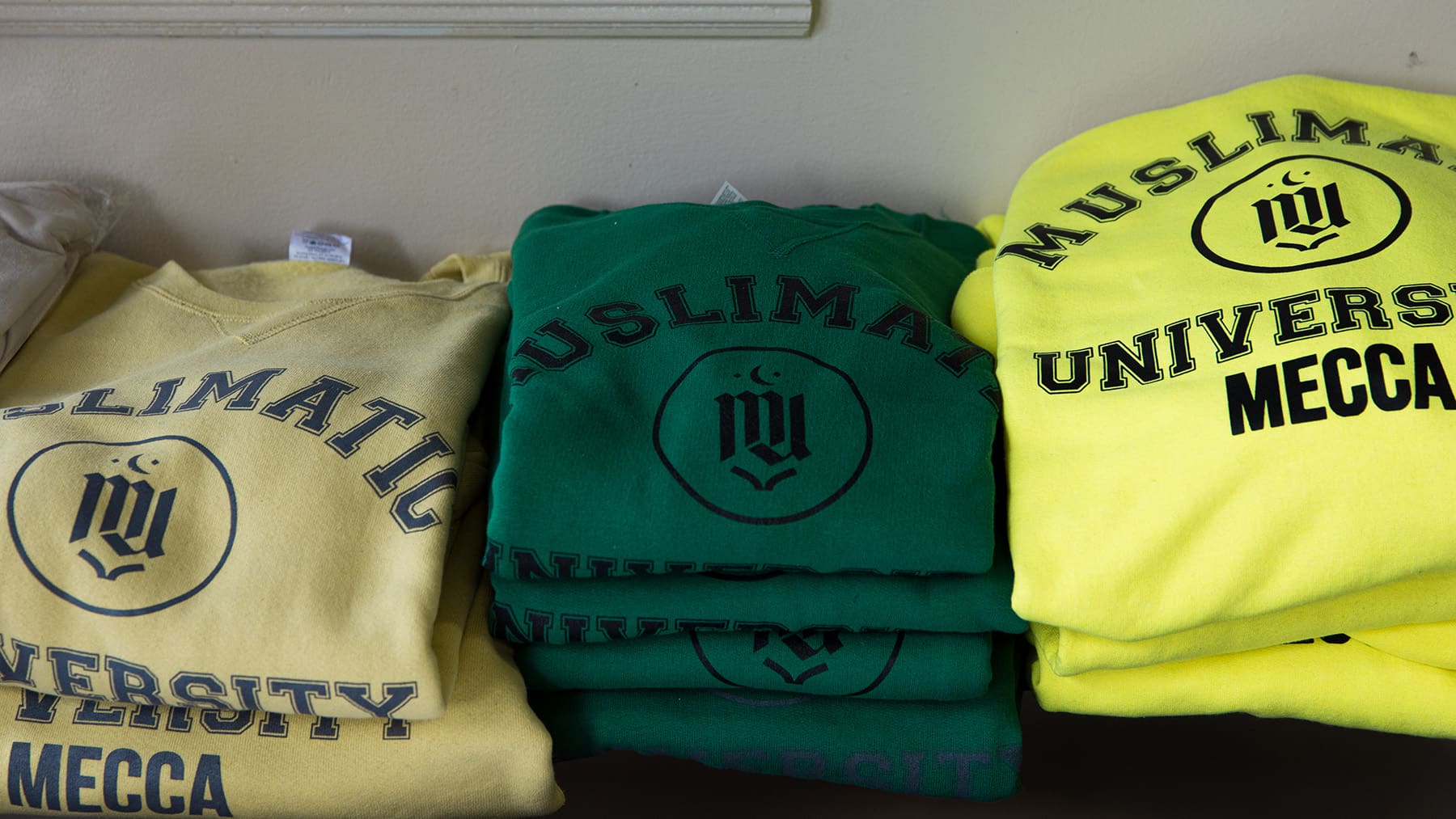 A pile of Muslimatic University Mecca sweatshirts