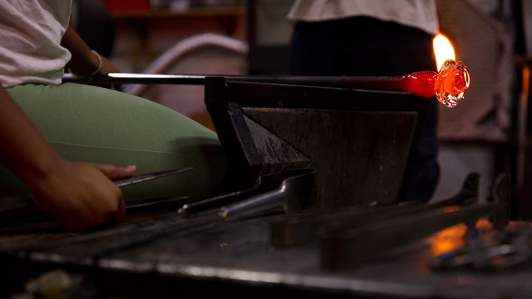 A glowing piece of glass attached to a glass blowing rod