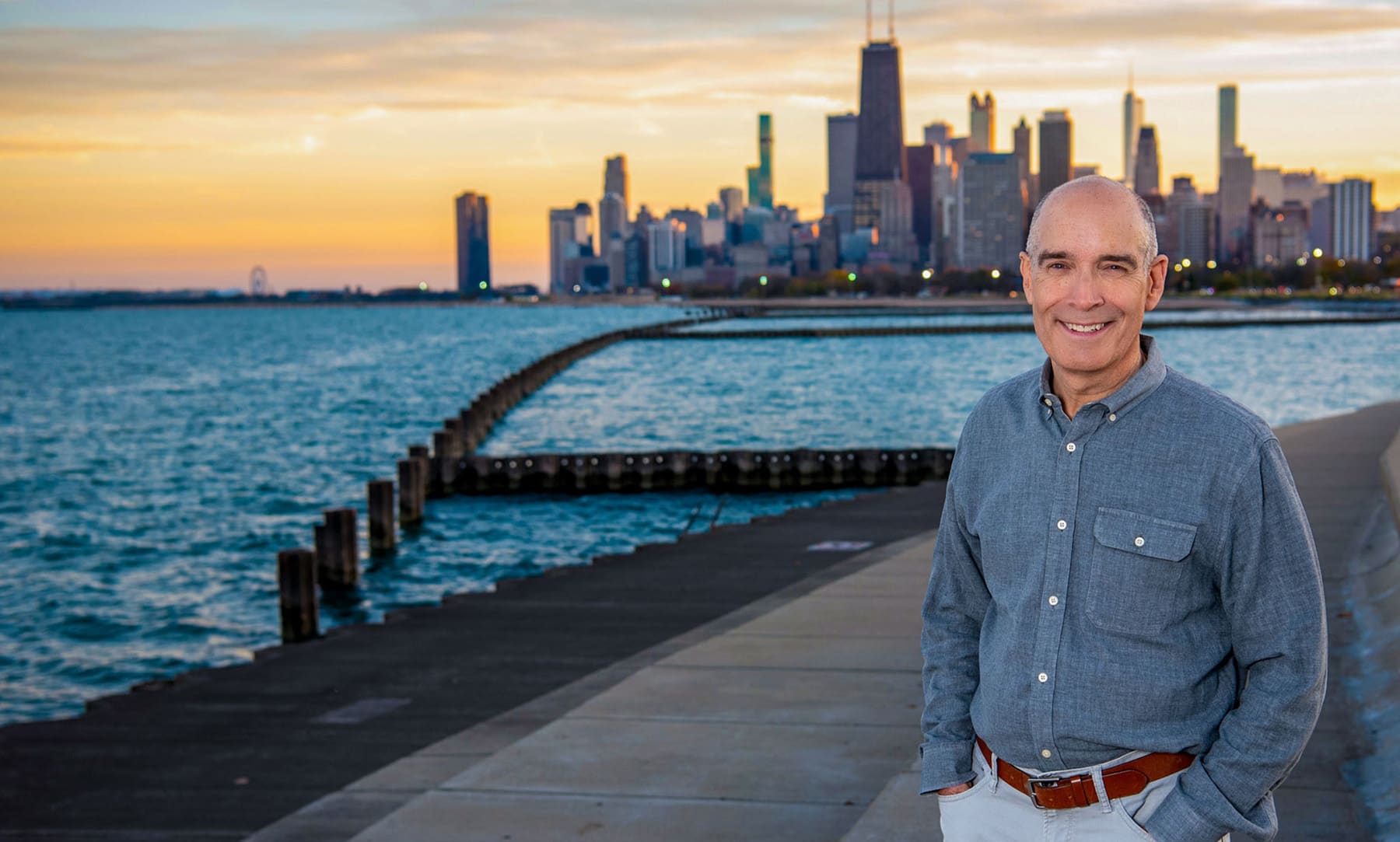 Geoffrey Baer poses near the lakefront with the Chicago skyline in the distance