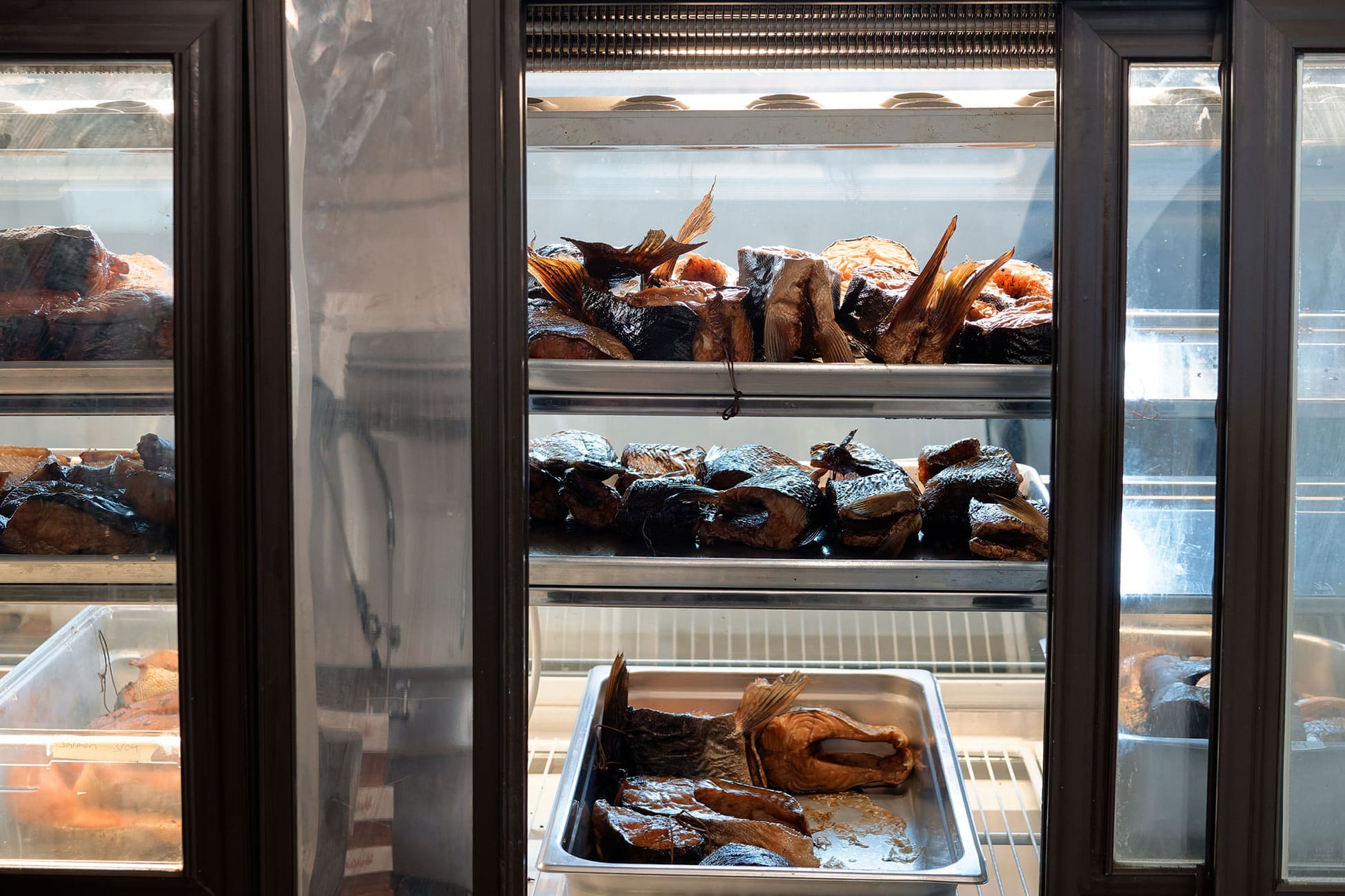 Smoked fish await customers in the refrigerated display case.