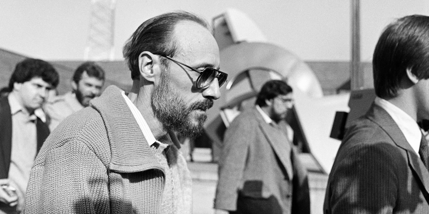 Black and white photo of Roger Arnold walking with others