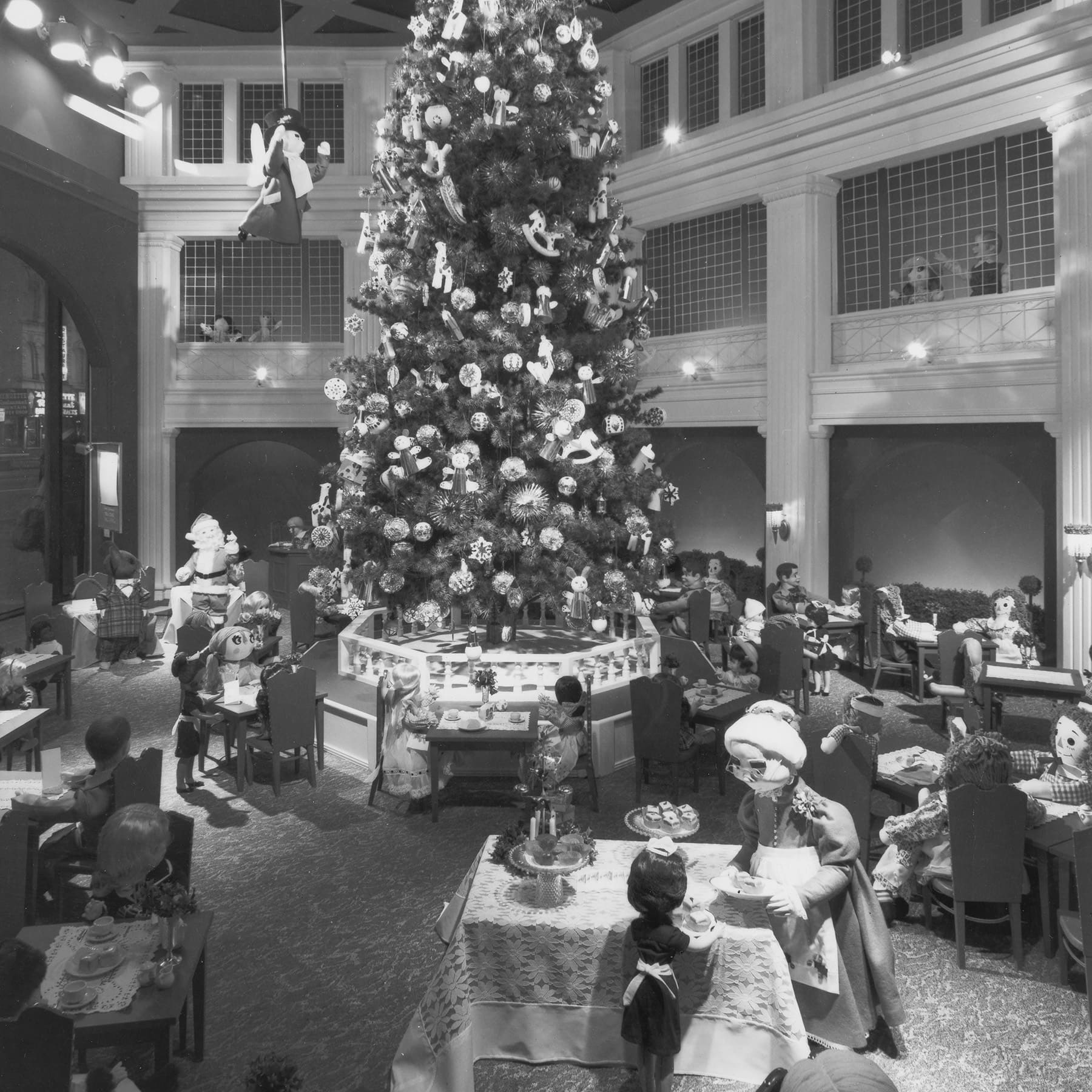 A black and white photo of a window display recreating the decorated Christmas tree inside the Walnut Room.