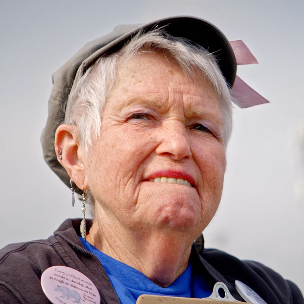 Julee with 'Abolish ICE' shirt and buttons on speaking into a megaphone