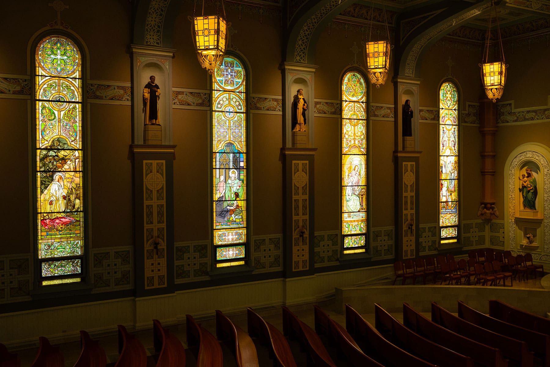 The image shows the interior of Old St. Patrick's Church in Chicago, Illinois, highlighting its historic stained glass windows and pews