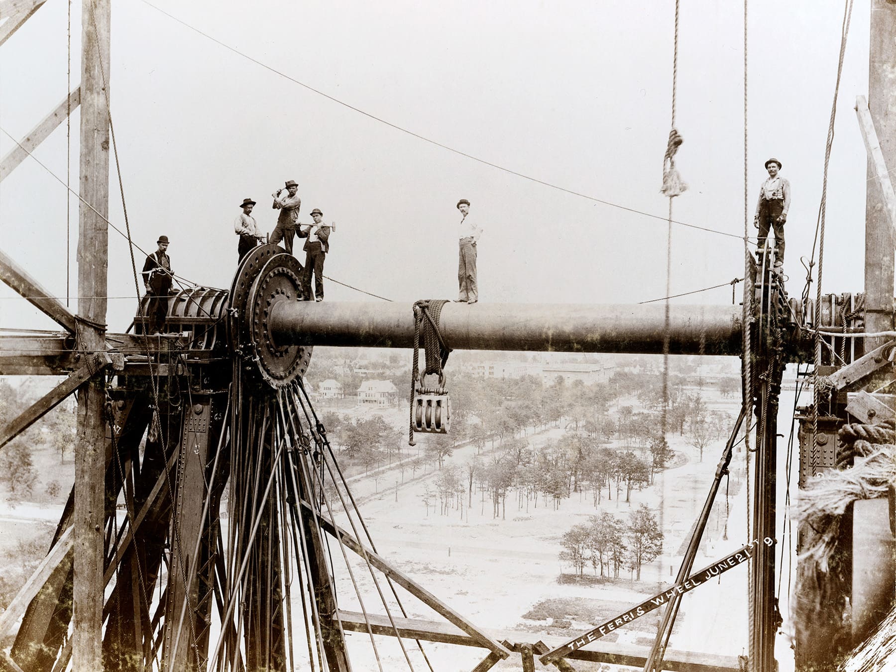 Workers atop an axis on the Ferris wheel