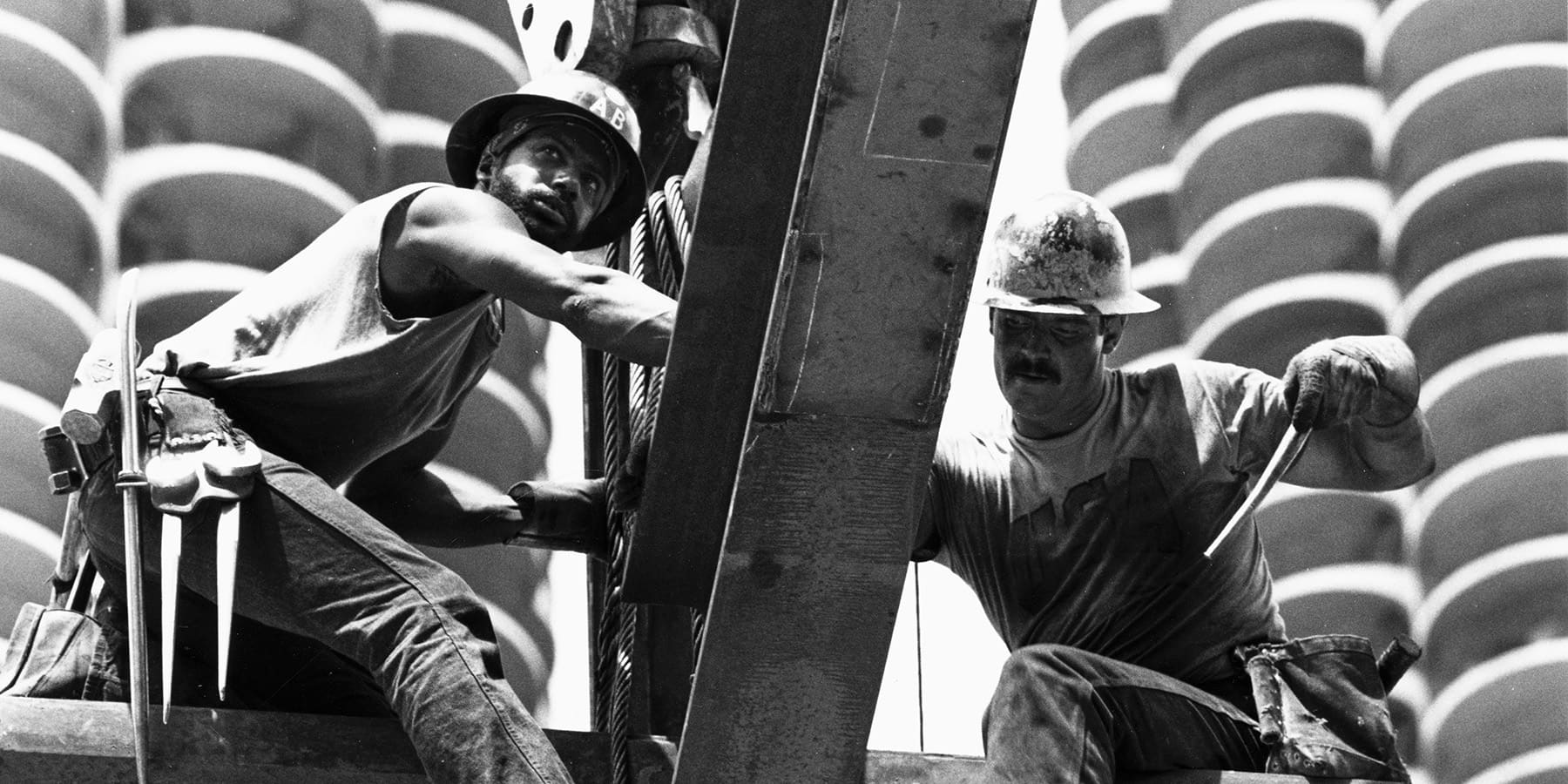 Two construction workers place a beam during the construction of 35 West Wacker Drive in 1987.