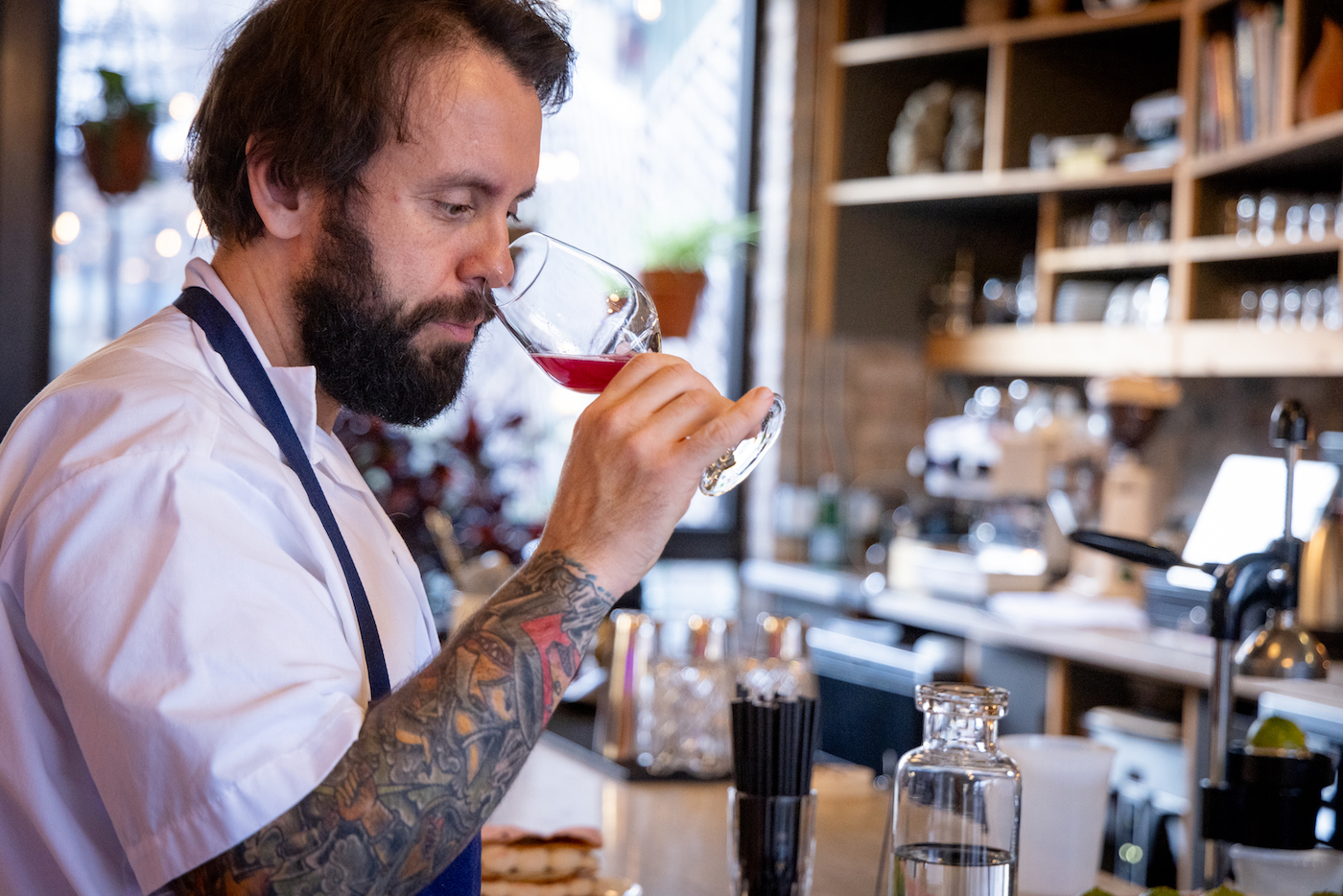 Chef Johnny Clark raises a wine glass of magenta kvass to his nose