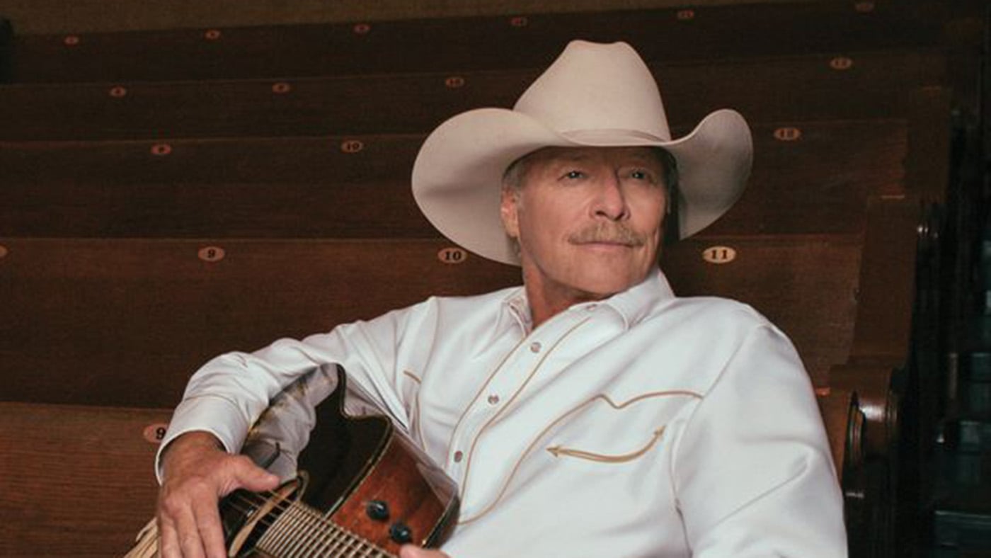 Alan Jackson in a cowboy hat with a guitar