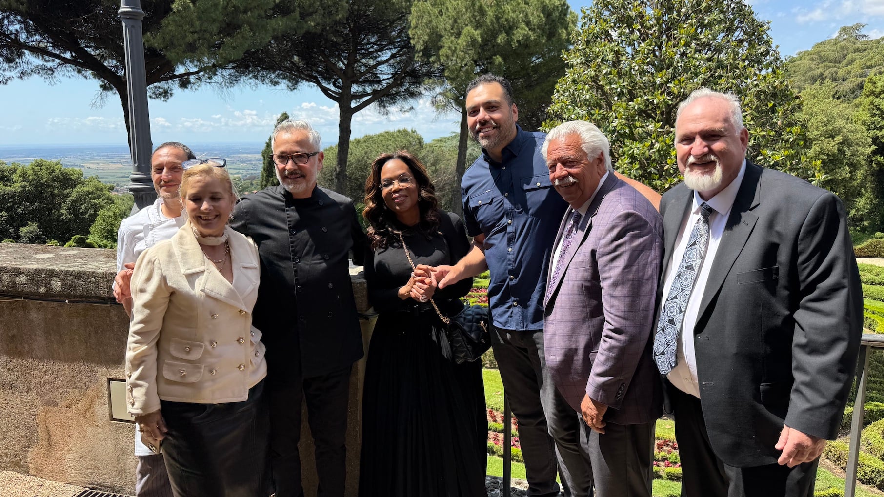 A group of people including Oprah pose for a photo outside