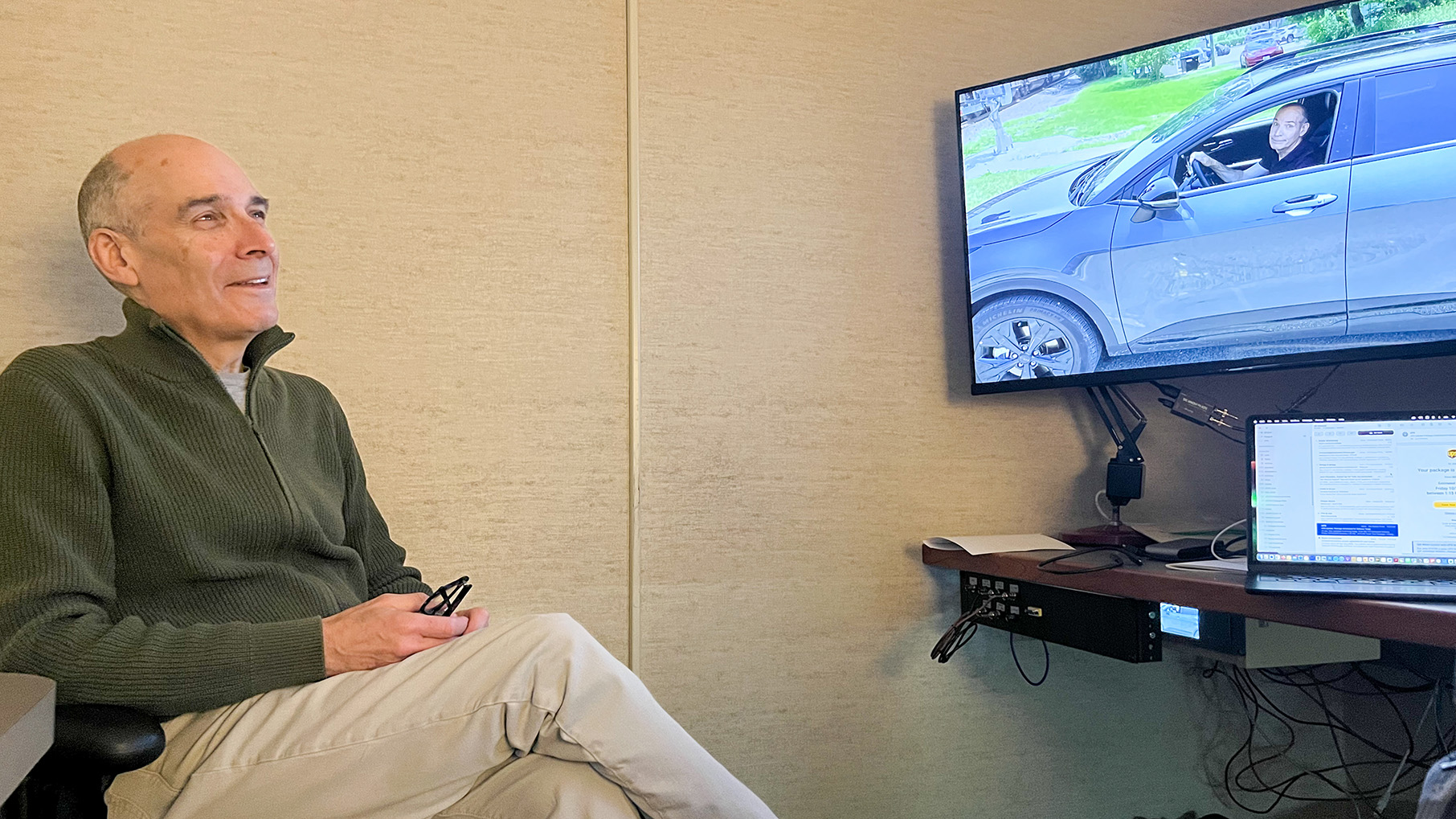Geoffrey Baer watches a “tease” for his next program as it is being edited. 