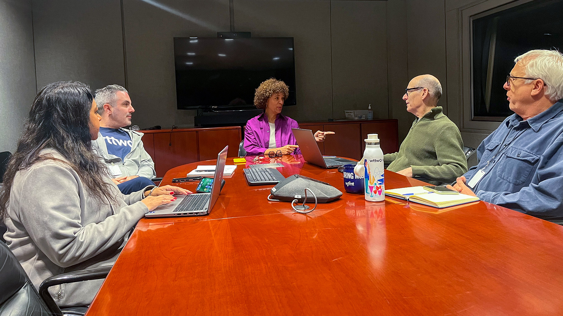 A group of people sit around a conference table