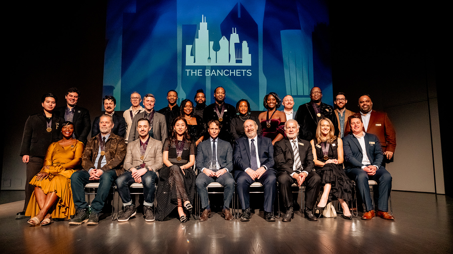 The winners of the Banchet Awards sitting together on a stage