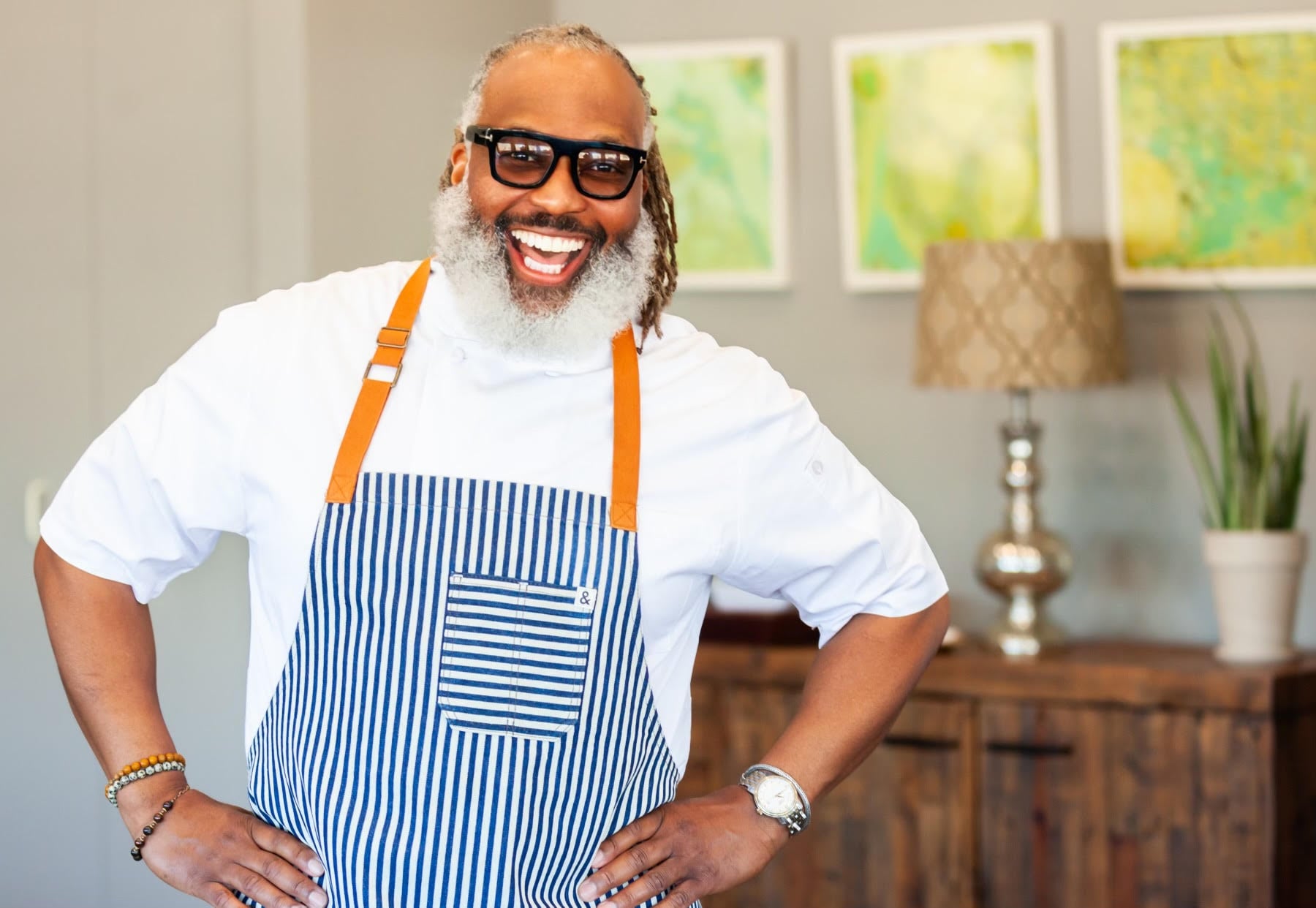 Cliff Rome smiles in an apron with his hands on his hips