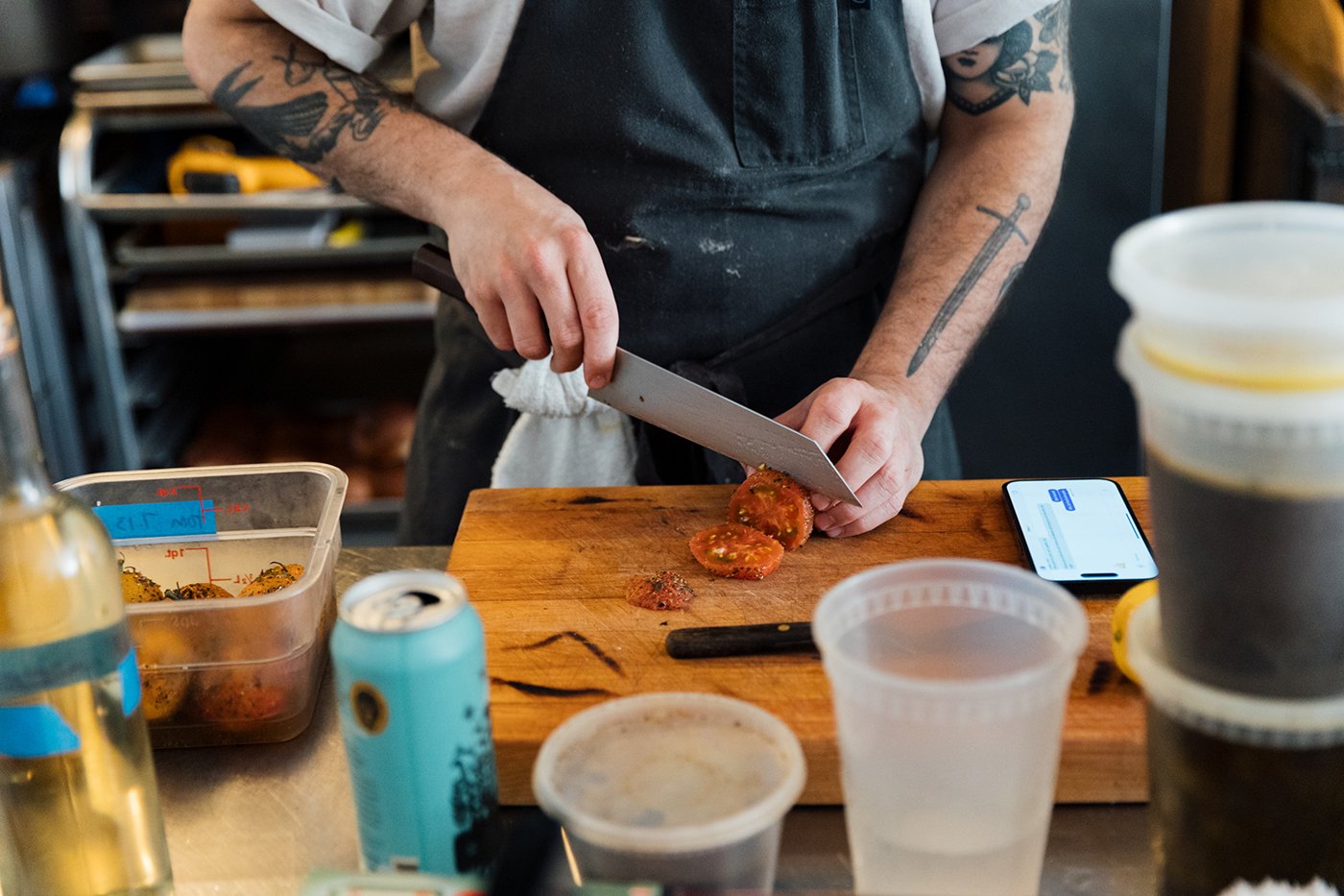 A person slices a tomato on a cutting board
