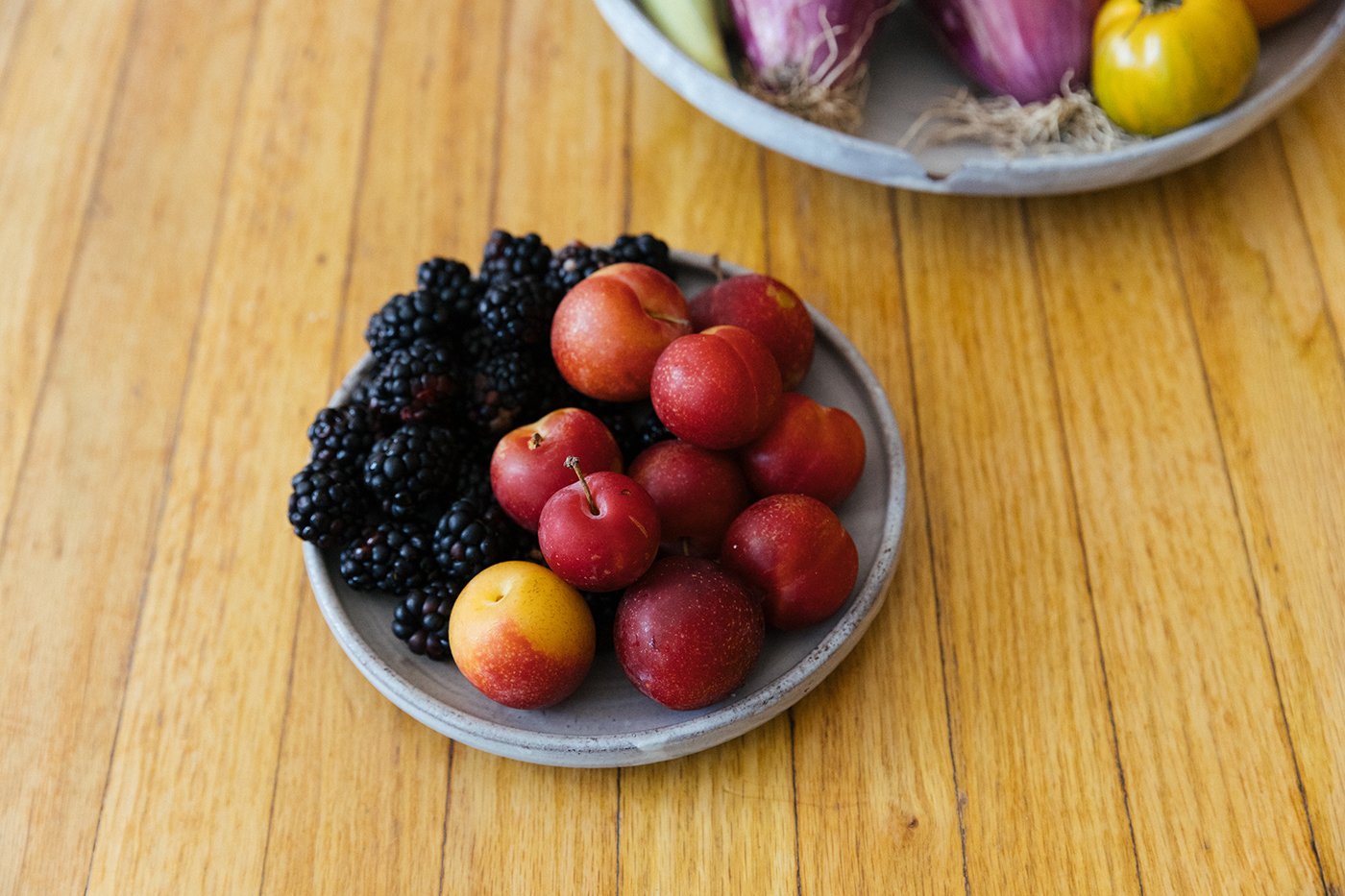 Cherry plums and blackberries on a plate