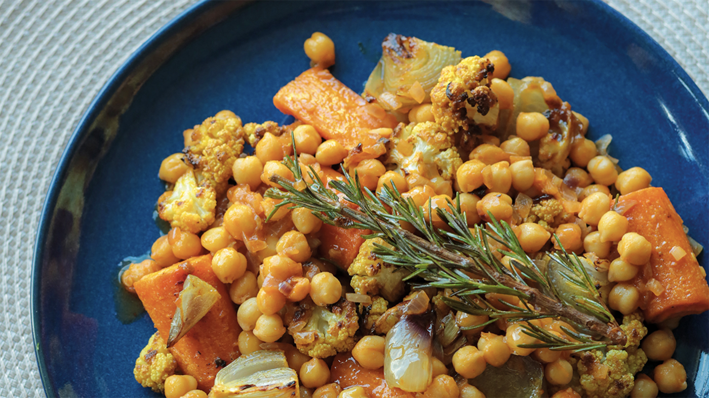 Diane Kochilas' Chickpea Stew with Honey-Roasted Cauliflower and Root Vegetables in a blue dish