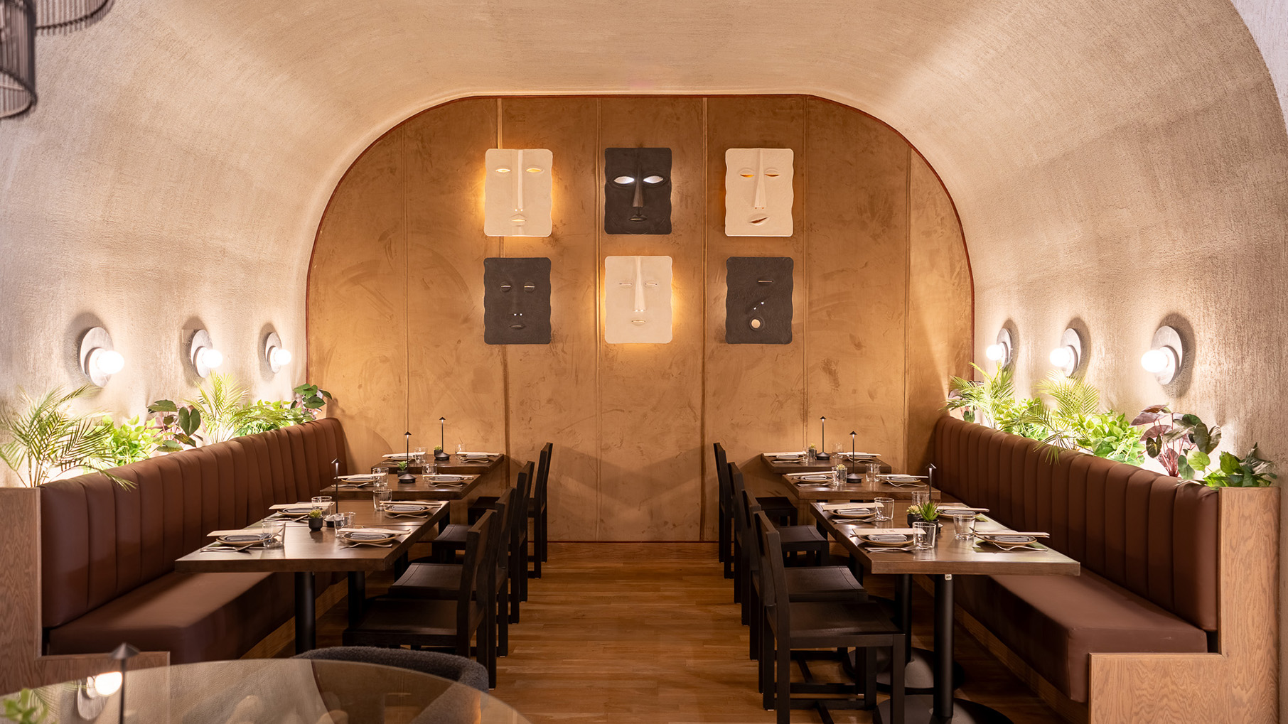 Tables in a curved enclosure, with masks on the wall