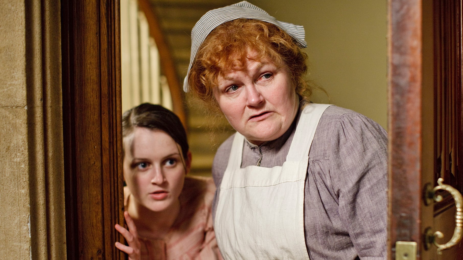 Daisy and Mrs. Patmore look through a doorway