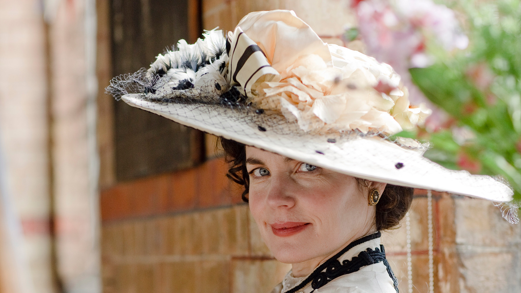 Cora smiles under a floral hat