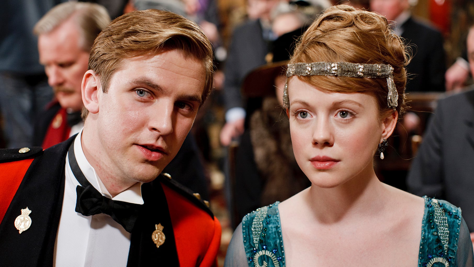 Matthew leans towards Lavinia, both dressed nicely