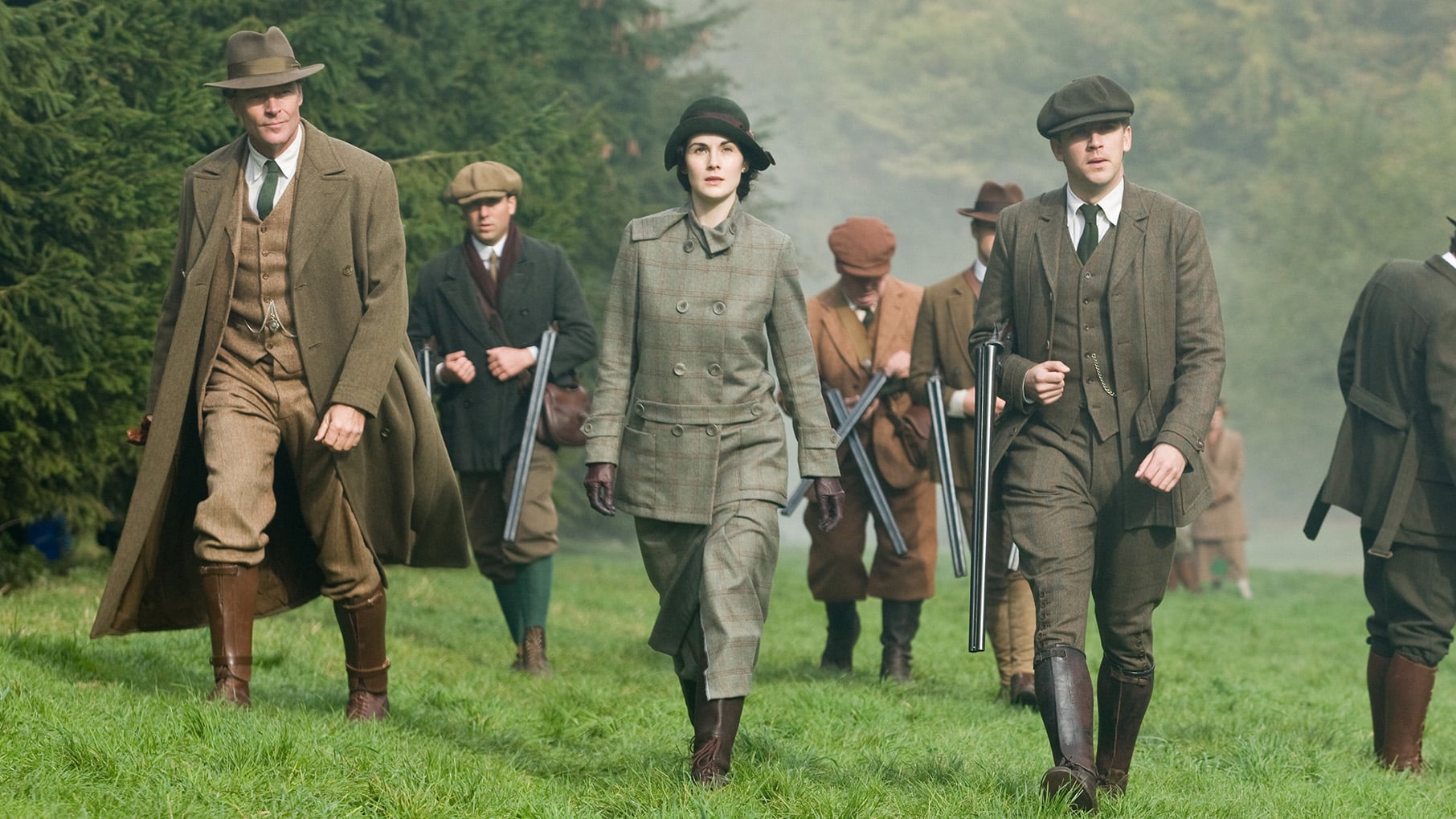 Some of the Downton household walk outside in hunting gear with guns