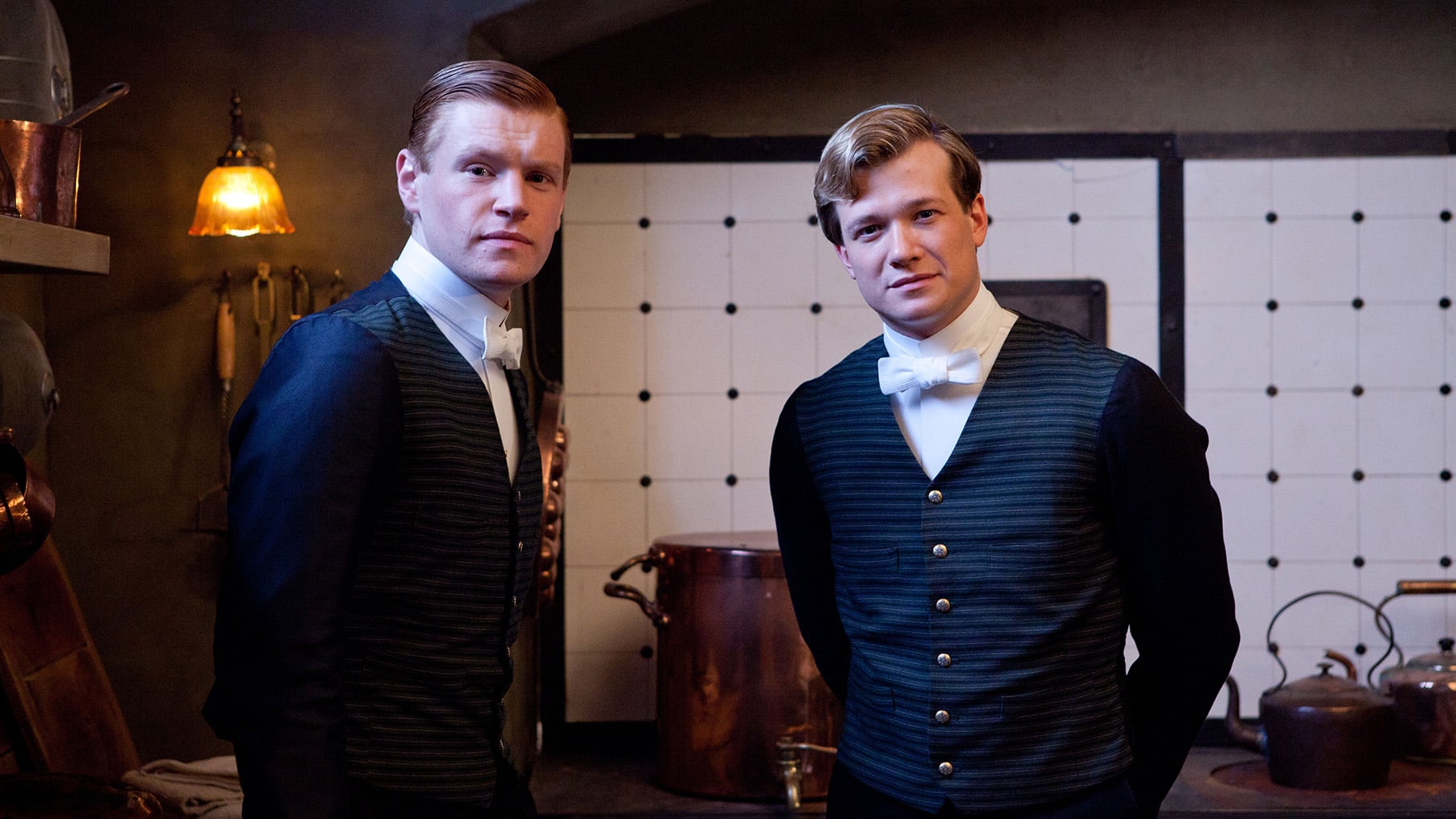 Jimmy and Alfred smile in the basement of Downton Abbey