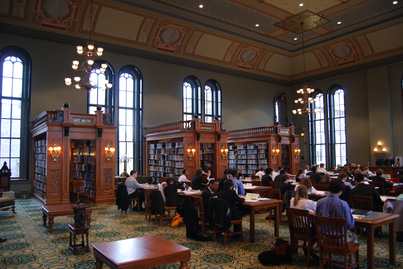 Students hosting Model UN at Foglia Library inside St. Ignatius College Prep in Chicago. Arts, music, mathematics, and religion book stacks visible in background.