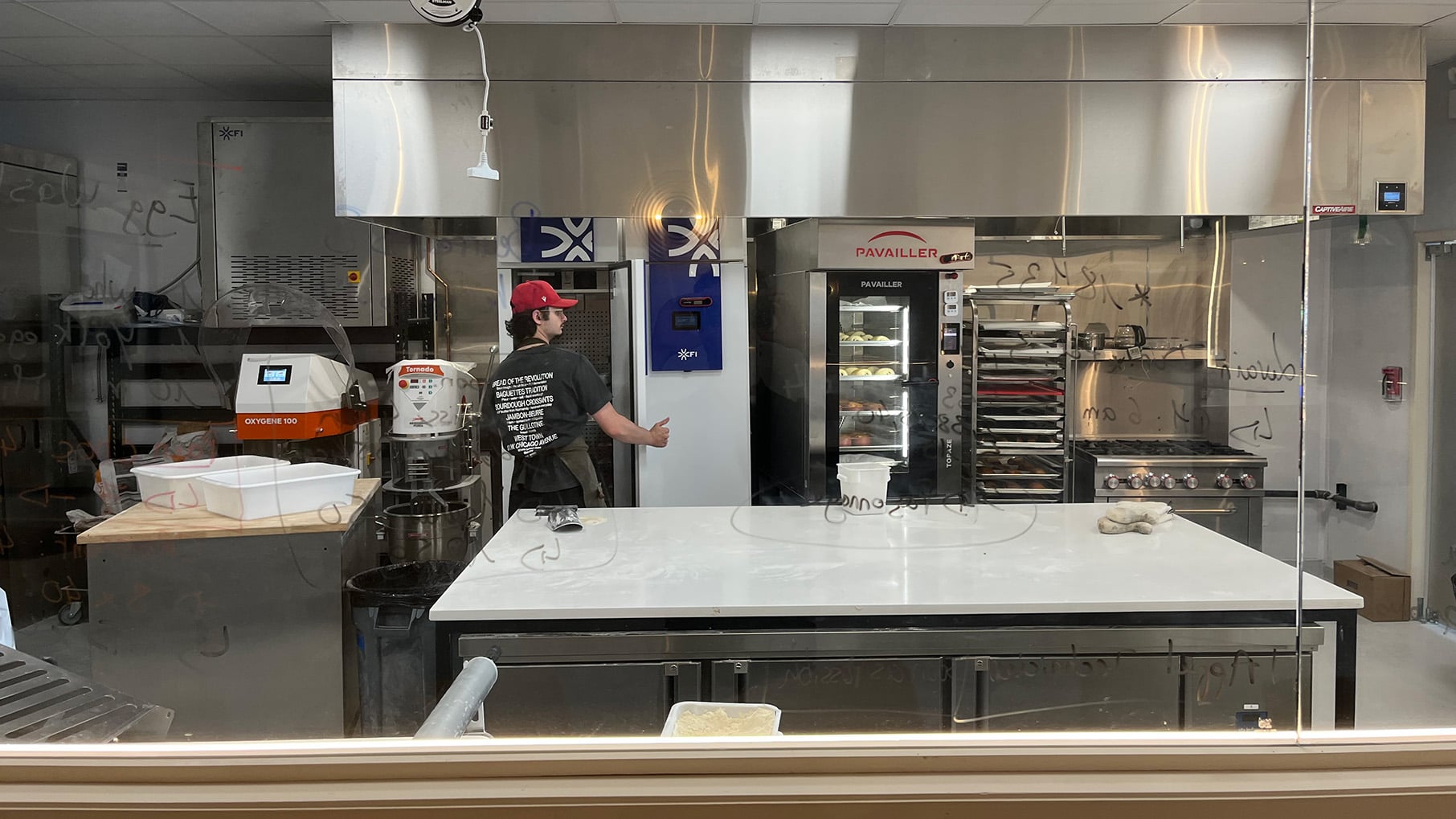 A worker inside an industrial kitchen for a bakery