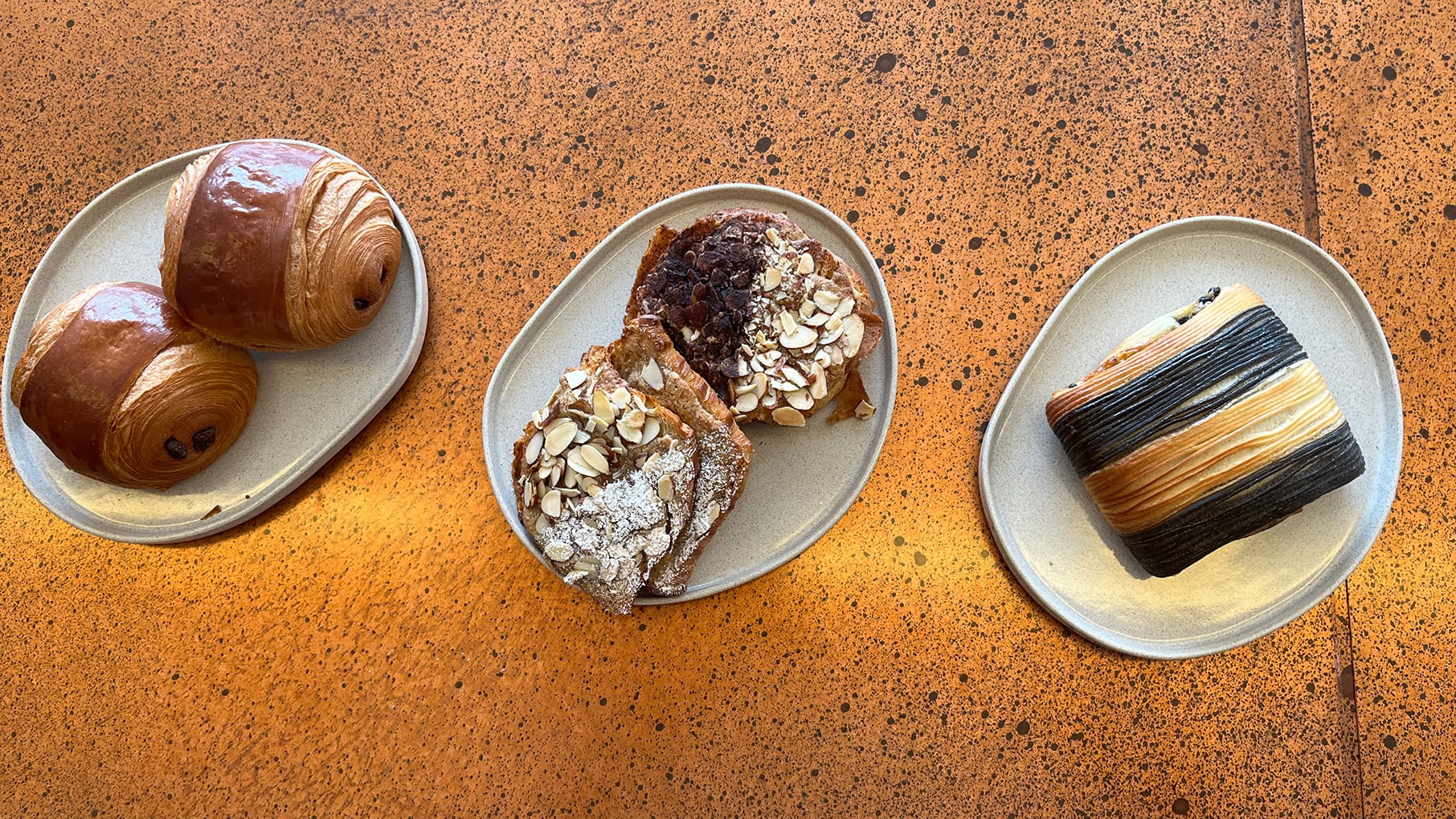 Three pastries on individual plates seen from overhead