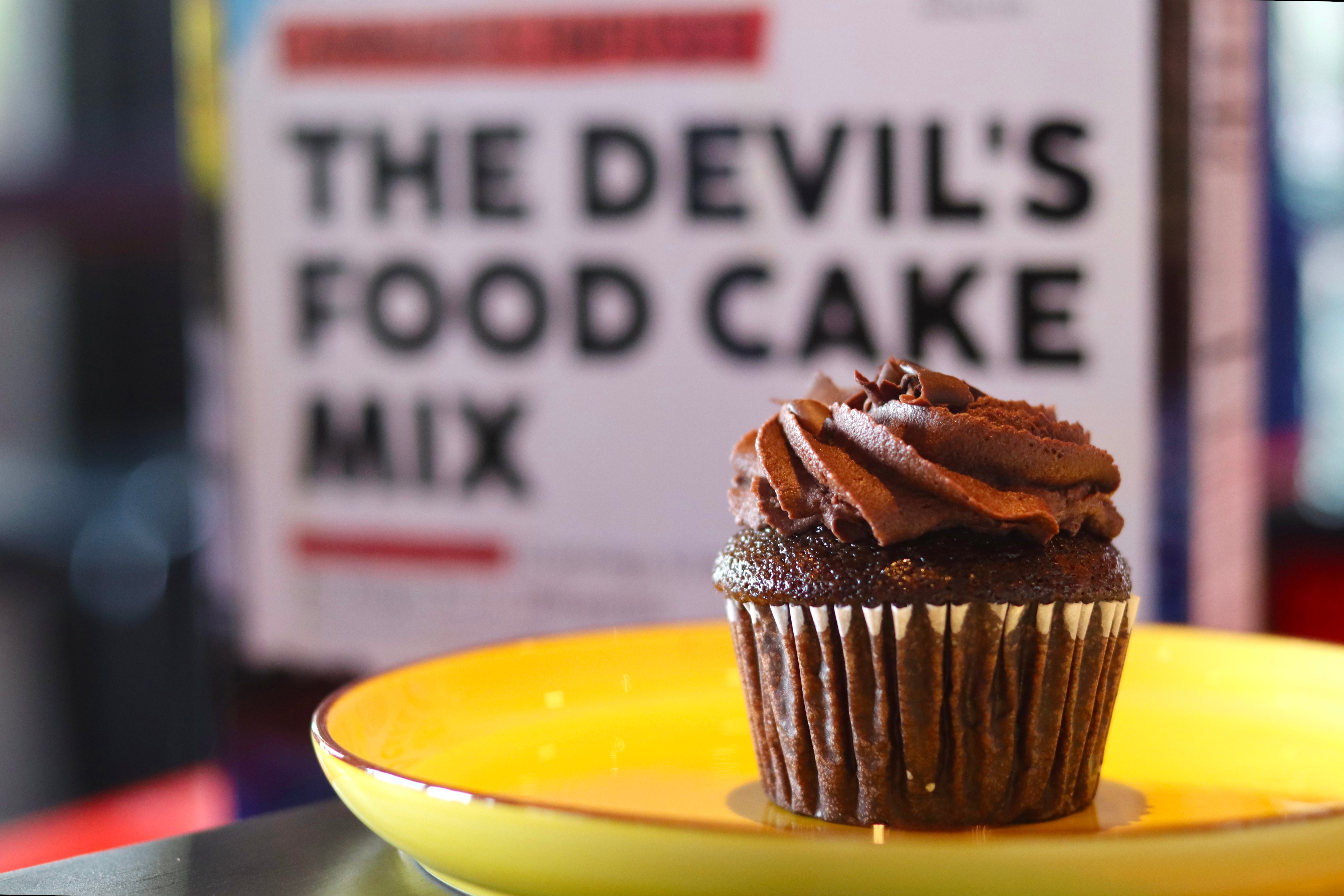 A chocolate, THC-infused cupcake on a yellow plate