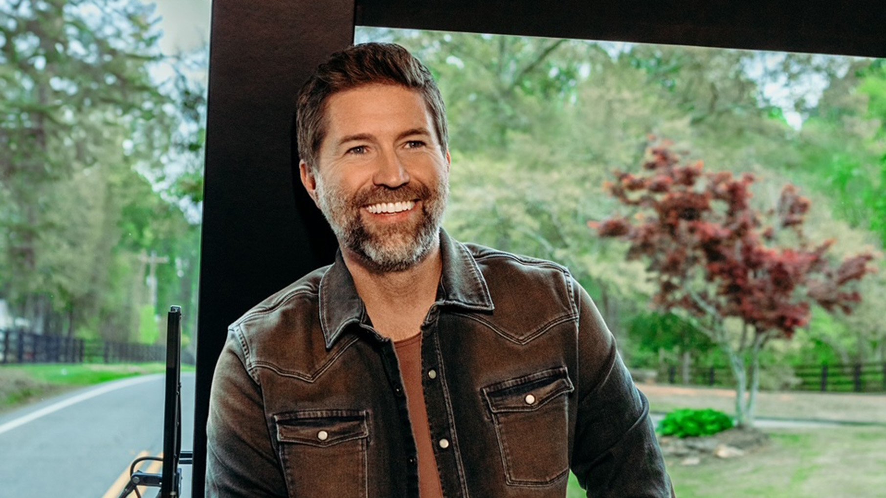 Josh Turner smiles in front of a window