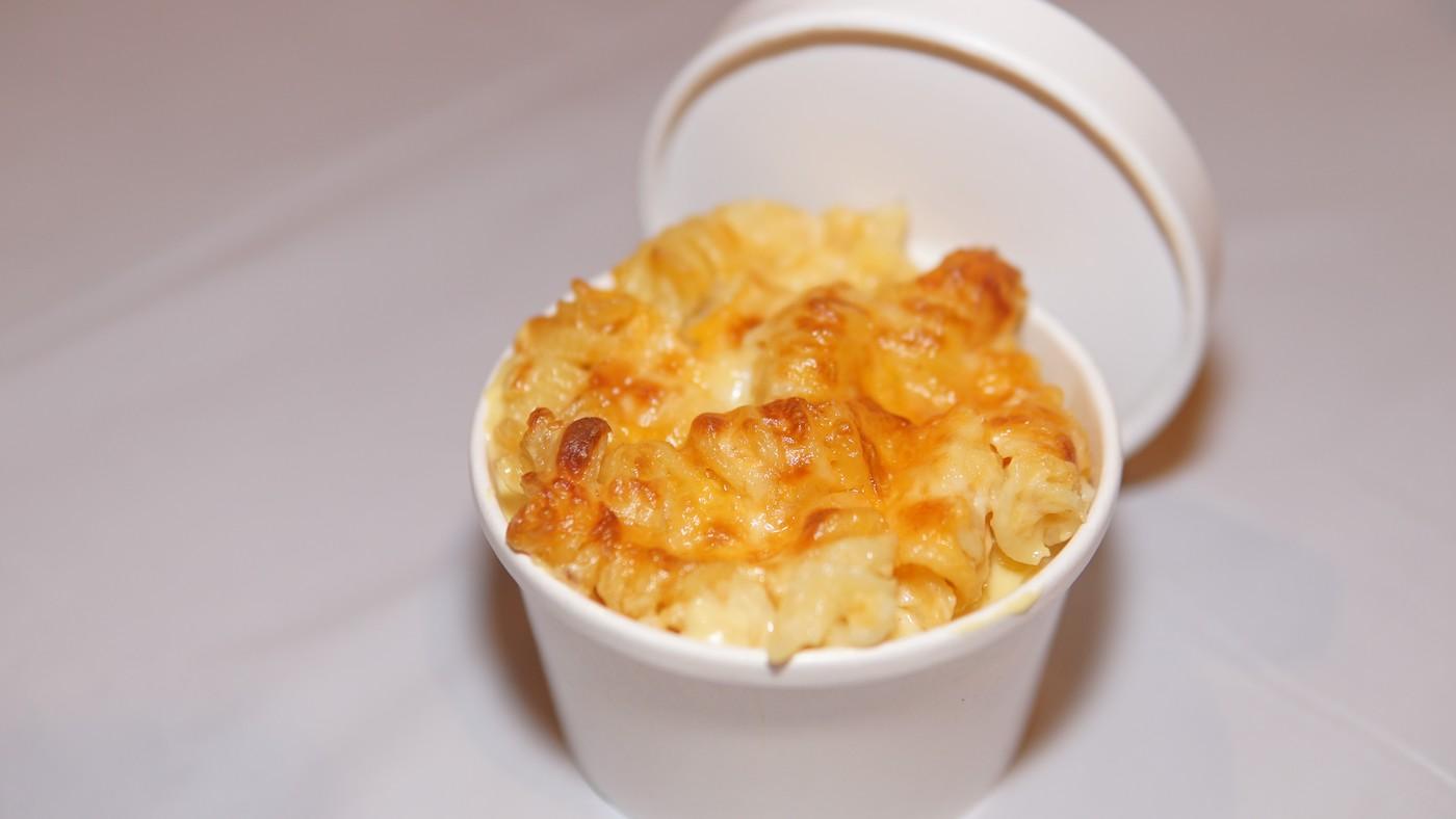 Mac n cheese in a round white takeout container