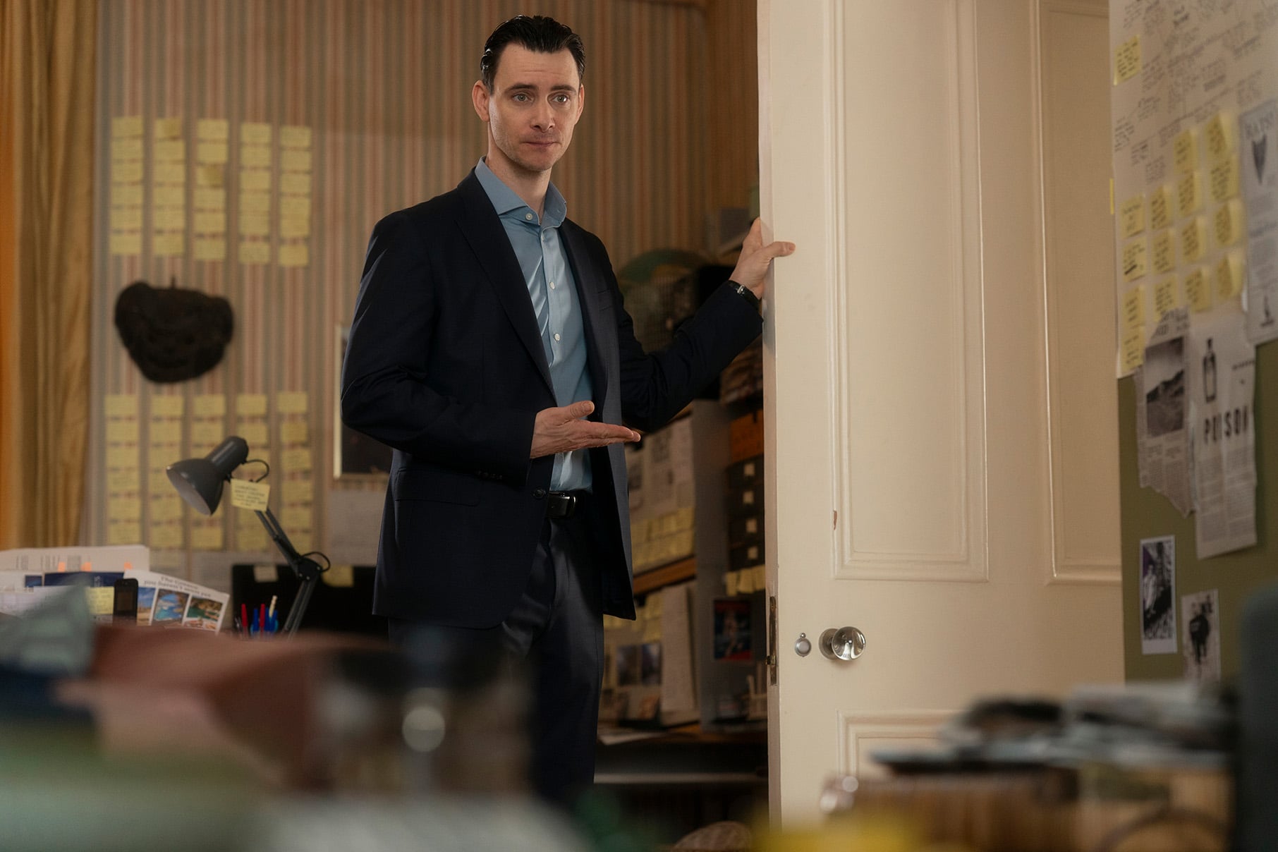Roland Crace stands holding a door