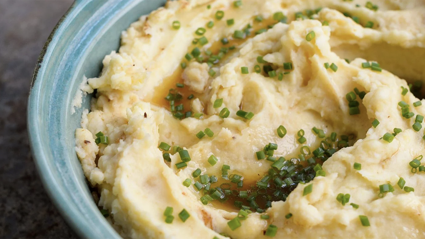 Mashed potatoes with caraway-mustard butter in a blue bowl