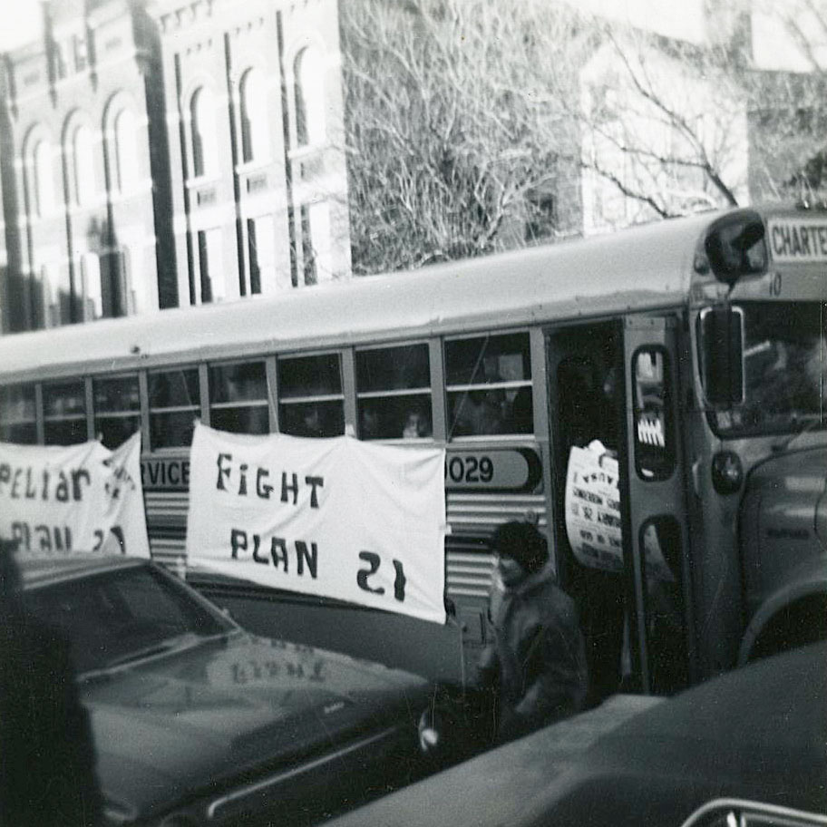Members of the community arrive on buses and spill into the streets to protest Plan 21.