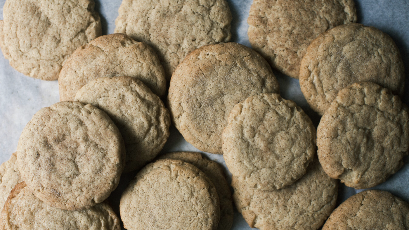 Pumpkin spice snickerdoodles spread out over a white background