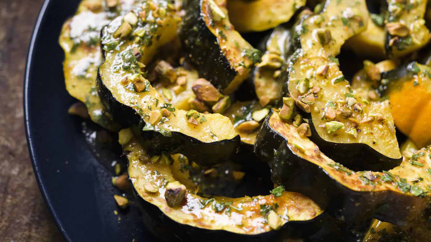 slices of roasted acorn squash on a dark blue plate