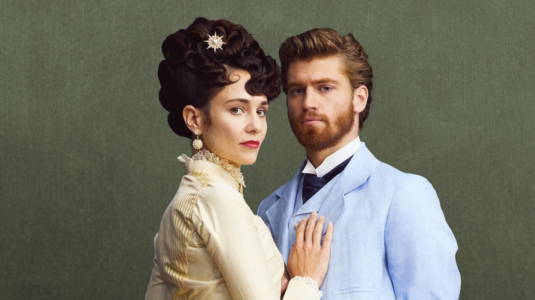 A woman in a yellow dress and hat has her hand on a man in a blue suit
