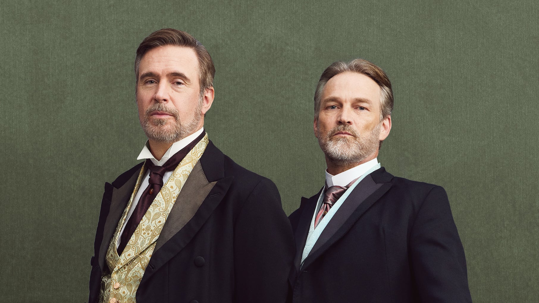 Two older gentlemen pose in suits