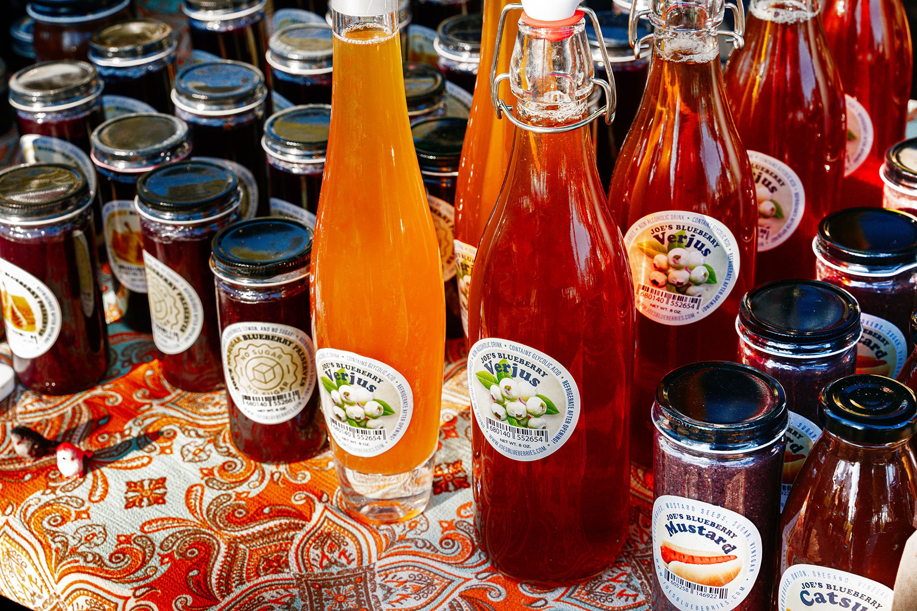 Bottles of jam and verjus lined up on a table